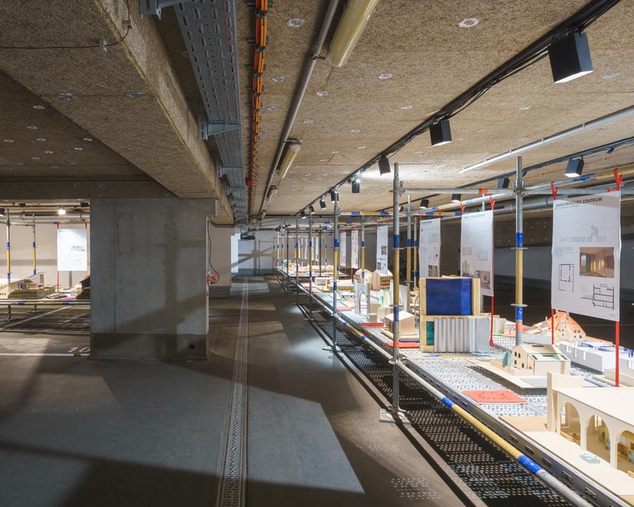 ADBK Jahresaustellung 2025, Blick in die Tiefgarage mit ausgestellten Modellen auf Baugerüst
