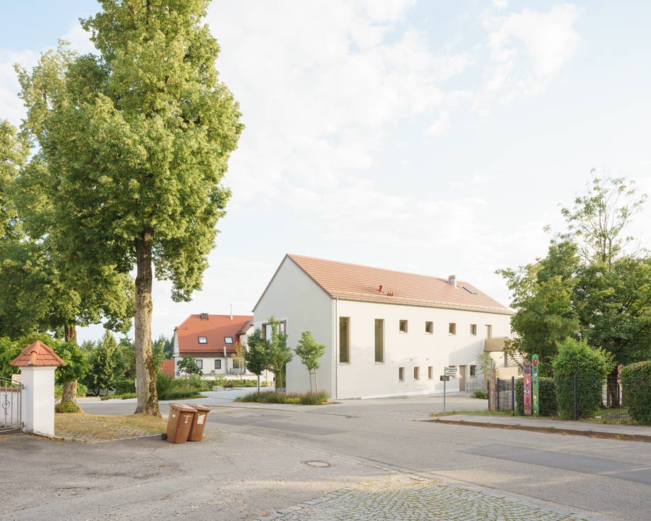Bürgerhaus Inning am Holz gegenüber der Kirche, Biotonnen des Friedhofs im Vordergrund, 2026